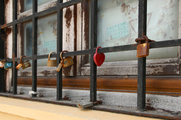 Love padlocks hang on a window grate of a historic building in Mandraki harbour, Rhodes, Greece