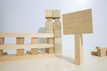 Building from wooden cubes and rods. The photo was taken on the white background and on the table. Close up.