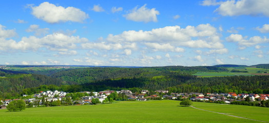 Fototapeta na wymiar weites Panorama über den Schwarzwald mit schönem Neubaugebiet direkt an den Wiesen im Frühling