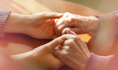 Elderly hands. Helping hands of young adult and senior women. Care and elderly concept.