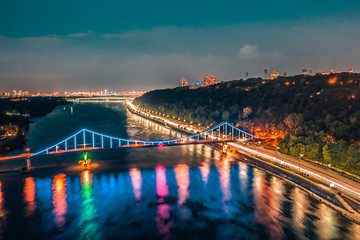 night cityscape. aerial view. colorful led bridge across river and quay road in Kyiv