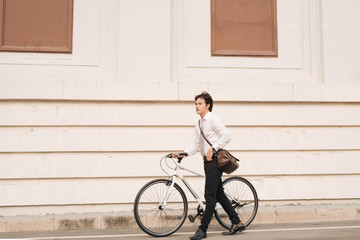 Outdoor portrait of handsome young man with fixed gear bicycle in the street.