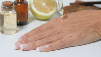 natural skin care applying natural serum on hands. Moisturizing treatment skin with natural...