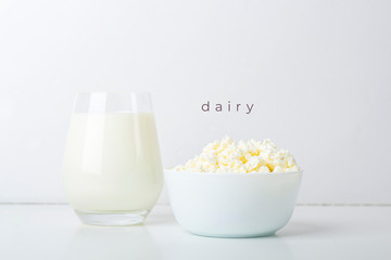 Glass of milk and bowl with homemade cottage cheese on a white background. The concept of healthy dairy products with calcium. Nutrition concept