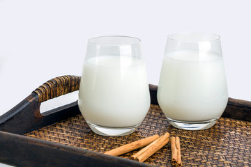 Two glass of vegatarian rice milk and rice grains served on a tray.  An invigorating healthy...