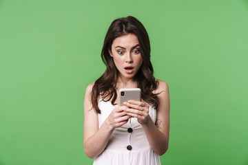 Image of shocked woman expressing surprise and using cellphone