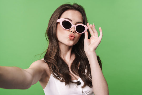 Image of funny woman making kiss lips and taking selfie photo