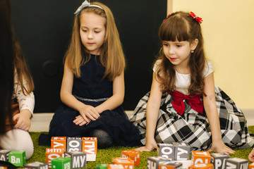 Fototapeta premium Childres sits with techers on the floor and learning. Preschool
