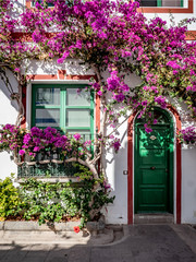 The brightly coloured, flower covered façade to a traditional fishermans house in Mogan, Gran Canaria, in the Canary Islands.