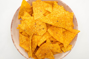 top view of corn nachos in bowl on white background
