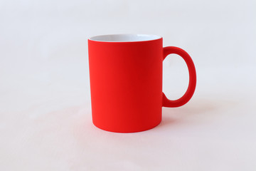 Red tea mug on a white background close-up.