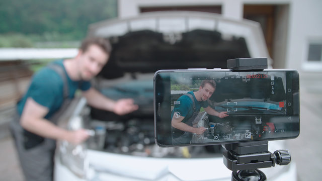 Smartphone recording a car specialist influencer