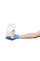 plastic bag hold in hand isolated on white background. man wearing gloves holding pack of sugar in palm. delivery during quarantine of coronavirus pandemic COVID-19. food supplies, donation, volunteer