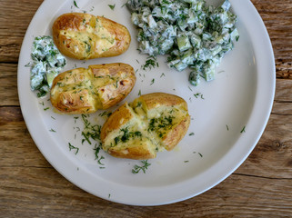 Baked potatoes with cheese and cucumber salad with sour cream.