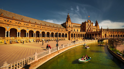 Seville, Spain - February 17th, 2020 - Plaza de Espana / Spain Square with the canal, wood rowing boats and beautiful architecture details in Seville City.