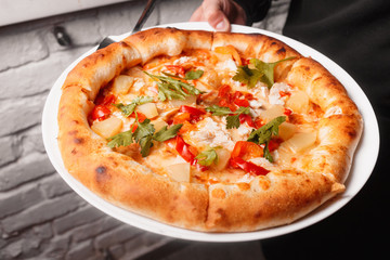 Tasty Italian pizza with cheese, pepperoni, arugula, cocktail tomatoes and  grilled bell pepper