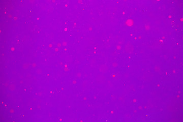 Abstract violet bokeh background. Defocused background. Blurred pink bright light. Circular points.