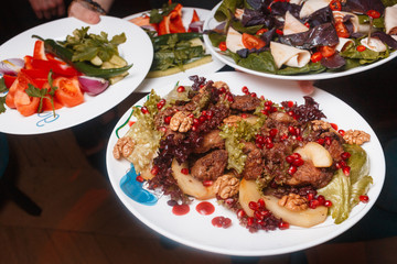 Grilled meat with vegetables served with pita on white plate