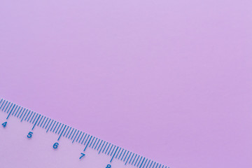 Top view of transparent ruler on the purple background. Minimalist flat lay image. Left side composition photo of ruler with copy space.