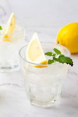 glasses with chilled drink with water with lemon and mint close-up
