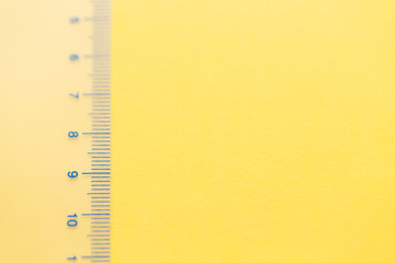 Transparent ruler with numbers on the yellow background. Measure concept. Left composition, copy space