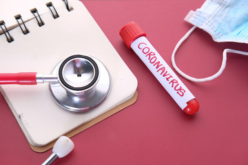 blood test tube, mask and stethoscope on red background 