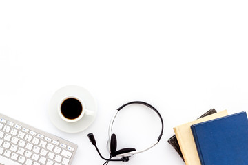 Office workplace. Headphones, keyboard, notebook on white desk top-down copy space