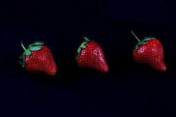 Three strawberries on a black background