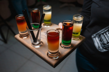 Set of alcohol short drinks served on wooden tray