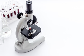Laboratory examination with microscope. Equipment with blood sample on white background copy space