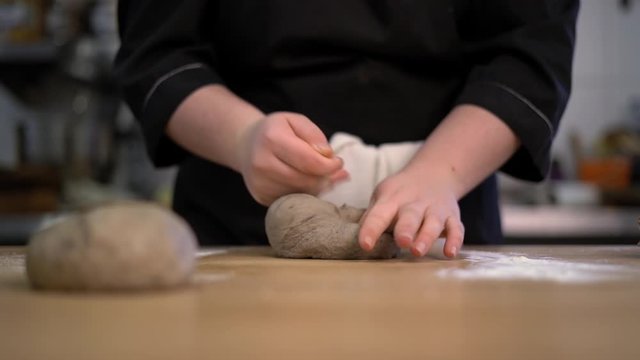 Female hands in black gloves kneading dough on table. Beautiful white flour-2.