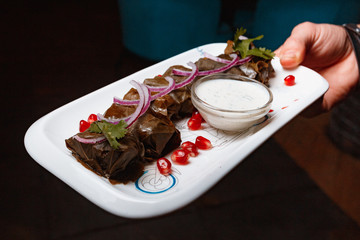 Grilled meat with vegetables served with sauce on white plate