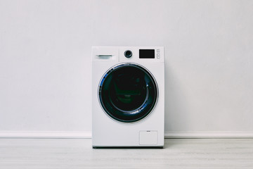 modern washing machine near white wall in bathroom - obrazy, fototapety, plakaty