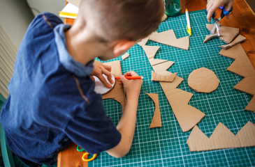 Boy making a cardboard dinosaur costume © Stock Rocket