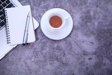 Top view of laptop, notepad, tea with copy space.