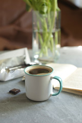 cup of coffee on the table, book and flowers, chocolate

