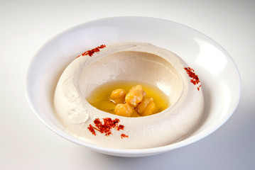 Bowl of hummus isolated on white background.