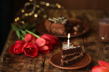 holiday table with cake with candles and flowers tulips, quarantined birthday.