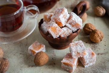 Turkish delight in a clay plate on a gray background close up