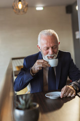 Senior businessman drinking coffee in restaurant