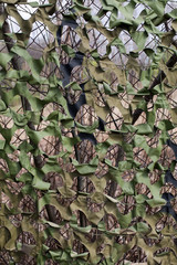Military camouflage net on the fence