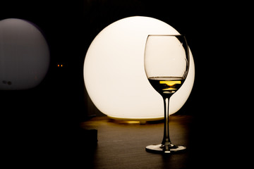 Glass of wine on round light background