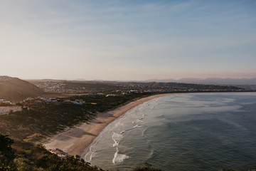 Fototapeta na wymiar View of Plettenberg Bay, a town by the sea from a hiker view on Robberg Nature Reserve Cliffs. 