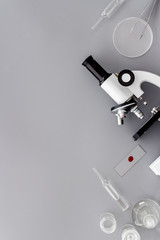 Research with microscope. Laboratory backround with blood sample on grey table top view copy space