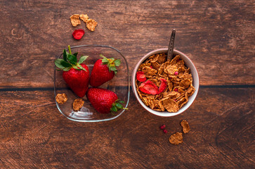 Cereal and fresh strawberries on table