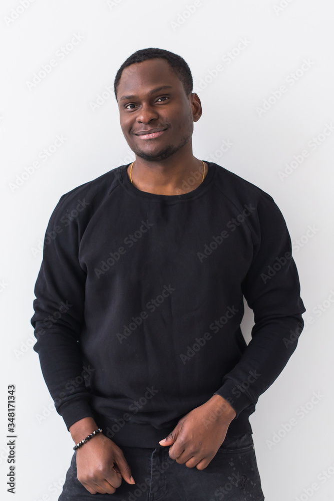 Wall mural Youth street fashion concept - Portrait of confident sexy black man in stylish sweatshirt on white background.