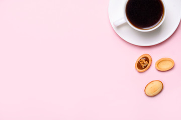 Homemade Russian nuts with condensed milk on a light pink background, wafer napkin. Cut nuts with condensed milk. Bitten goodies for coffee.