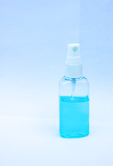 One blue antiseptic for hands in a glassy bottle on a light background