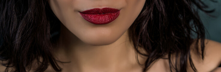 Close-up macro photo view of beautiful girl lips with red matt lipstick. Part of face, young woman.
