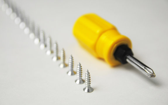 Motivation concept with screws and screwdriver. successful and fast work theme